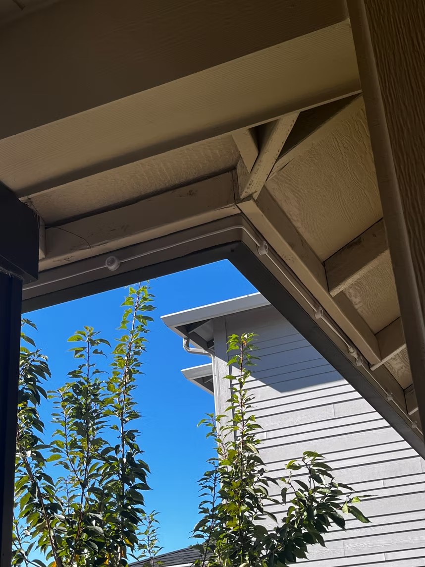 Daytime view looking up at the installed lighting beneath a home’s eaves