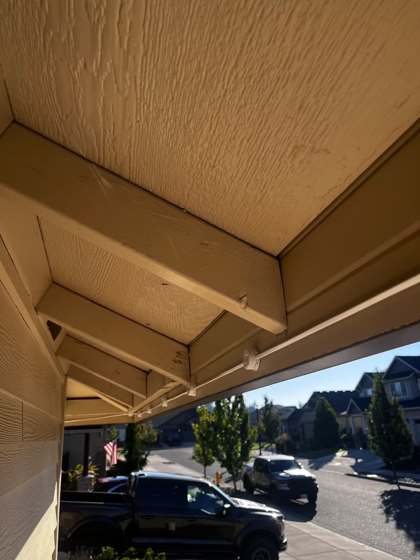 Daytime view along installed light pucks beneath an eave
