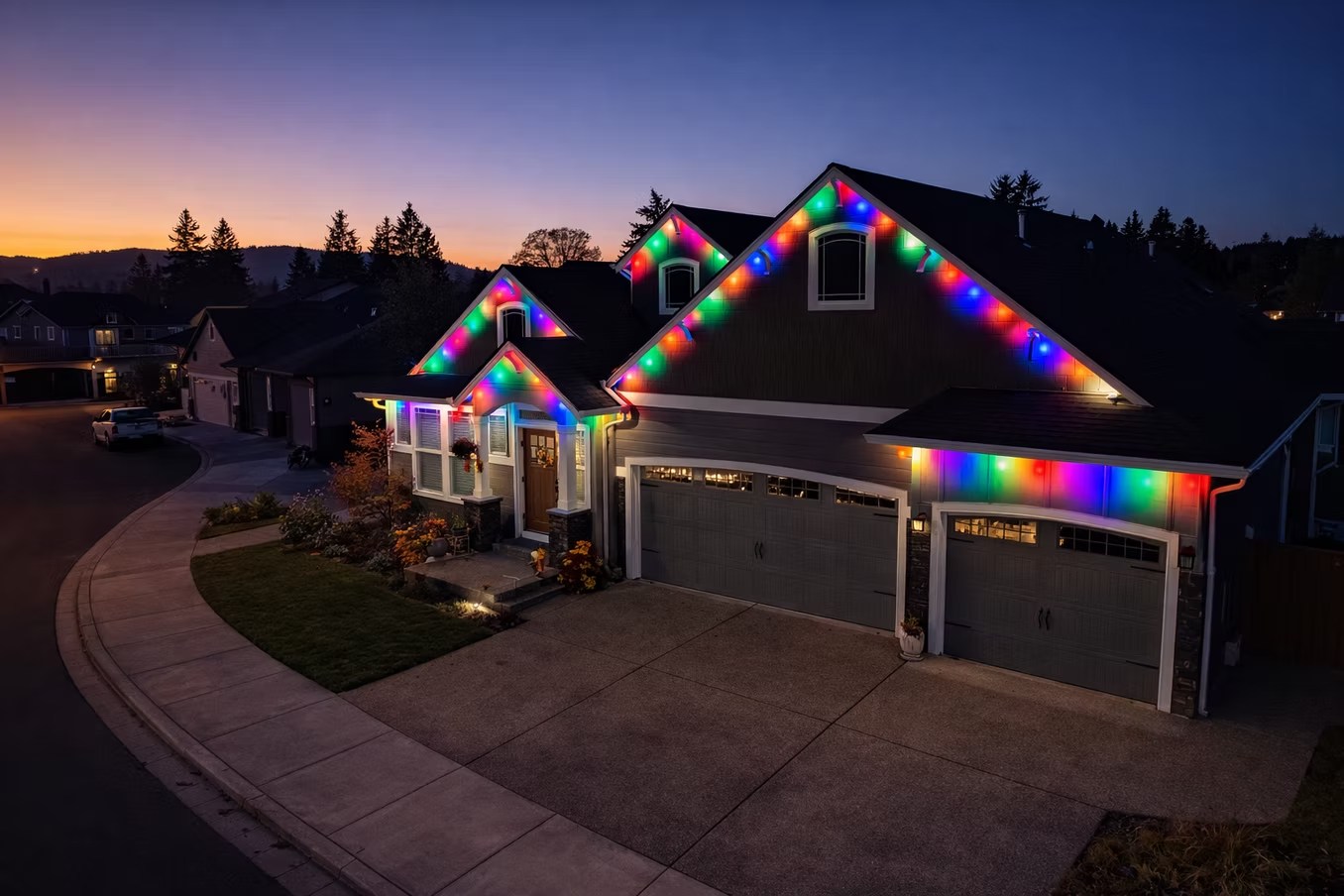Angled view of multicolor roofline lighting on a home at sunset