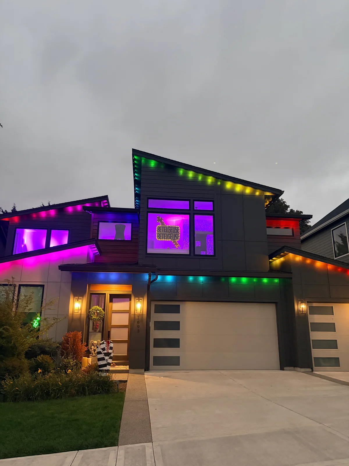 Rainbow roofline lights on a modern two-story home at dusk